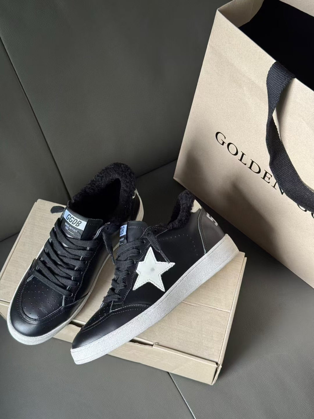 Black low-top sneakers with white star patch and white rubber outsole