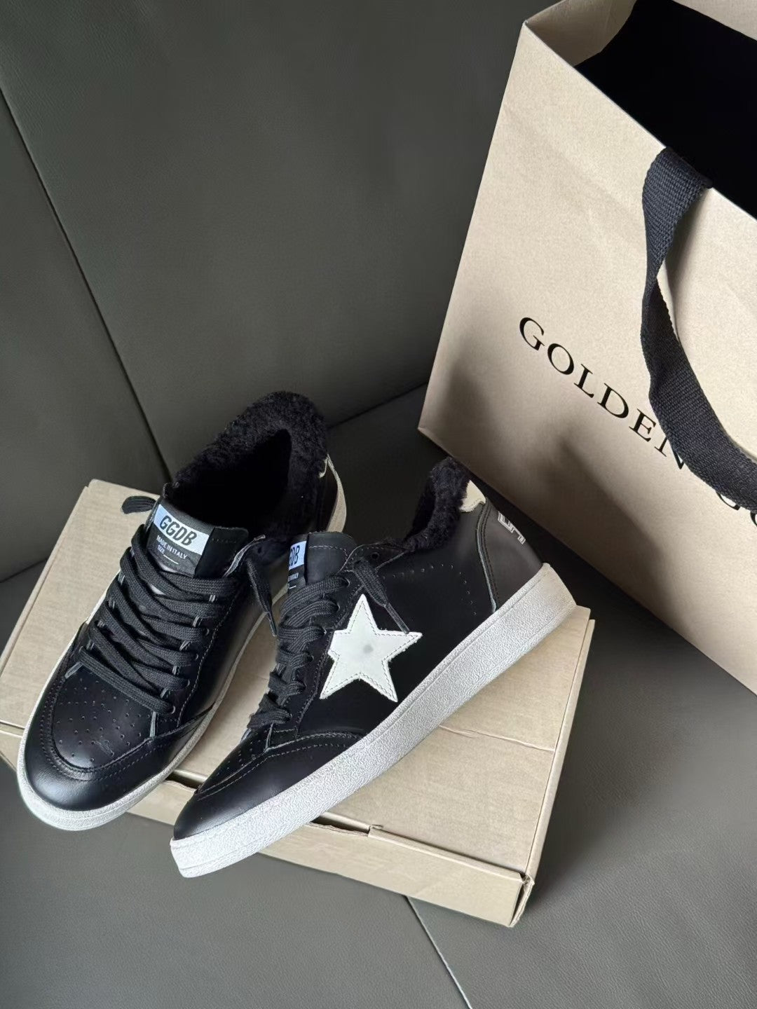 Black low-top sneakers with white star patch and white rubber outsole