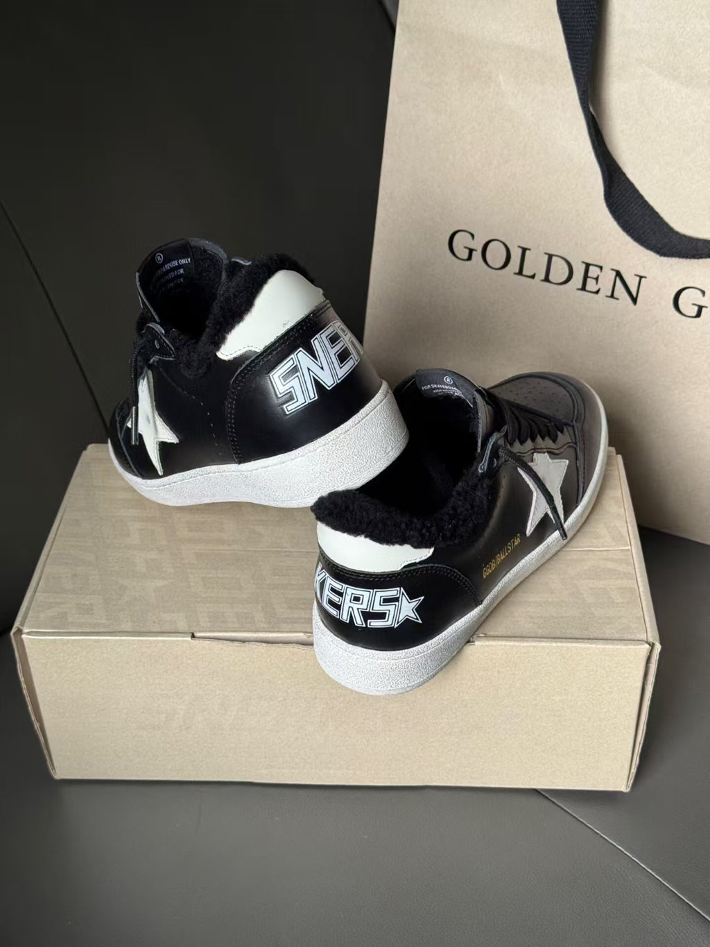 Black high-top sneakers with white rubber sole and star logo on side