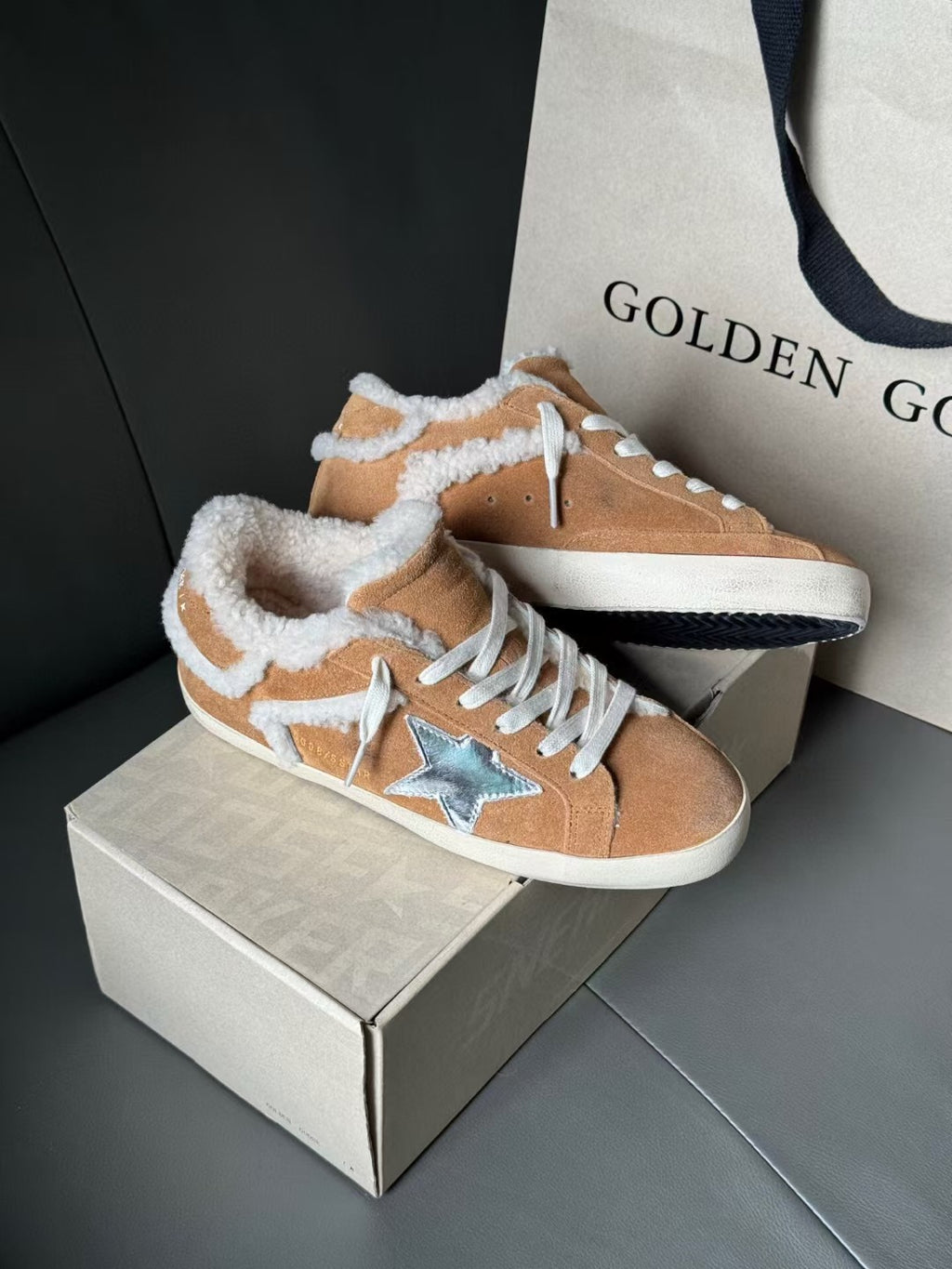 Brown suede high-top sneakers with white shearling lining, blue star emblem, and white sole.