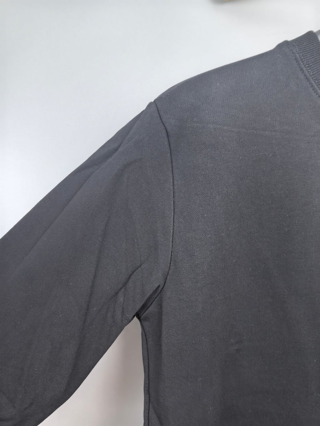 Dark charcoal sweatshirt shoulder and sleeve panel detail