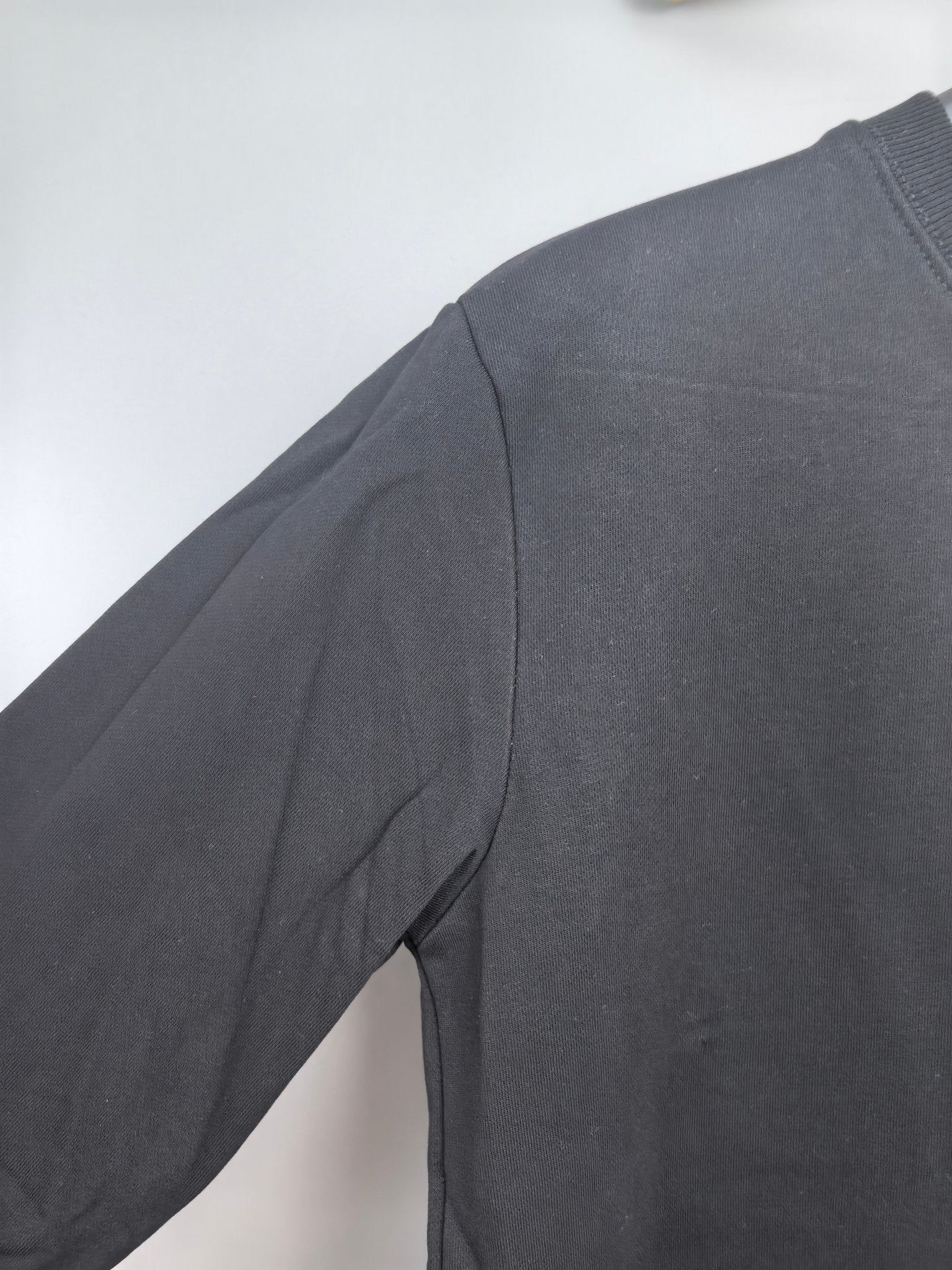 Dark charcoal sweatshirt shoulder and sleeve panel detail