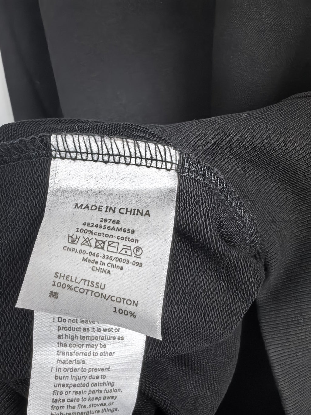 Dark charcoal sweatshirt care label with Made in China and cotton content