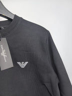 Dark gray crewneck sweatshirt with small chest logo detail