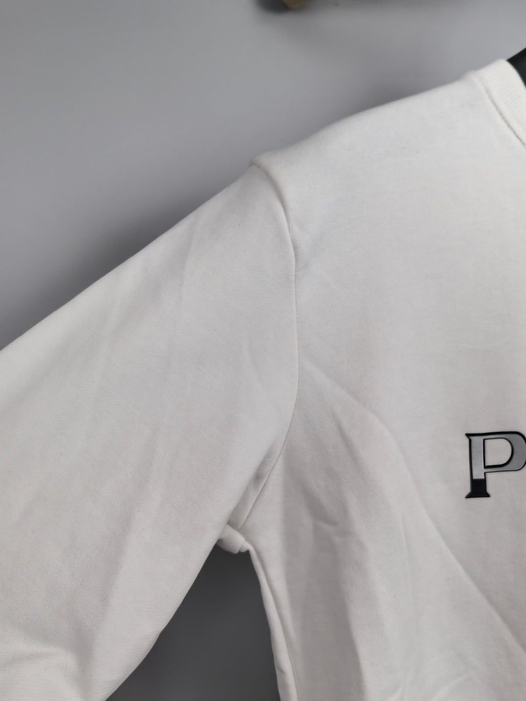 Long-sleeve sweatshirt, white, side view with partial PRADA logo