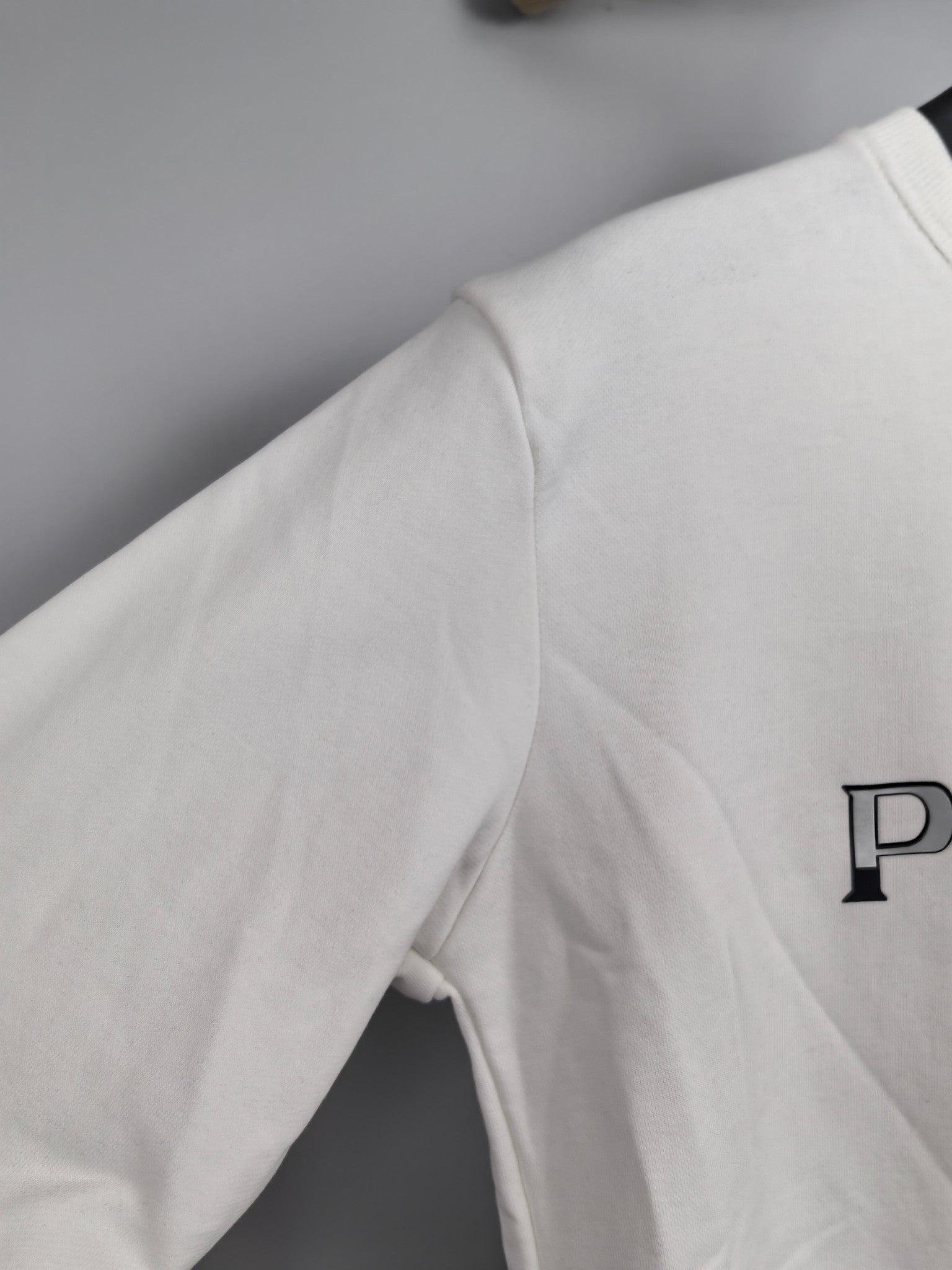 Long-sleeve sweatshirt, white, side view with partial PRADA logo