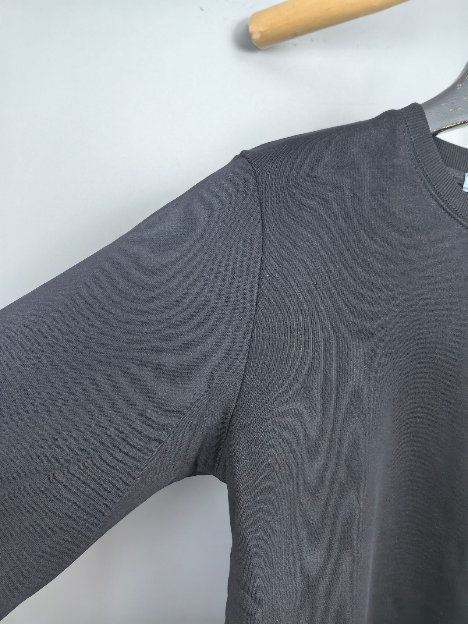 Dark gray long-sleeve sweatshirt sleeve and shoulder seam detail