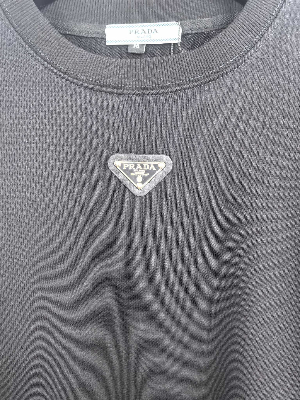Dark gray sweatshirt with small silver-toned Prada triangle logo on chest