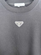 Dark gray sweatshirt with small silver-toned Prada triangle logo on chest