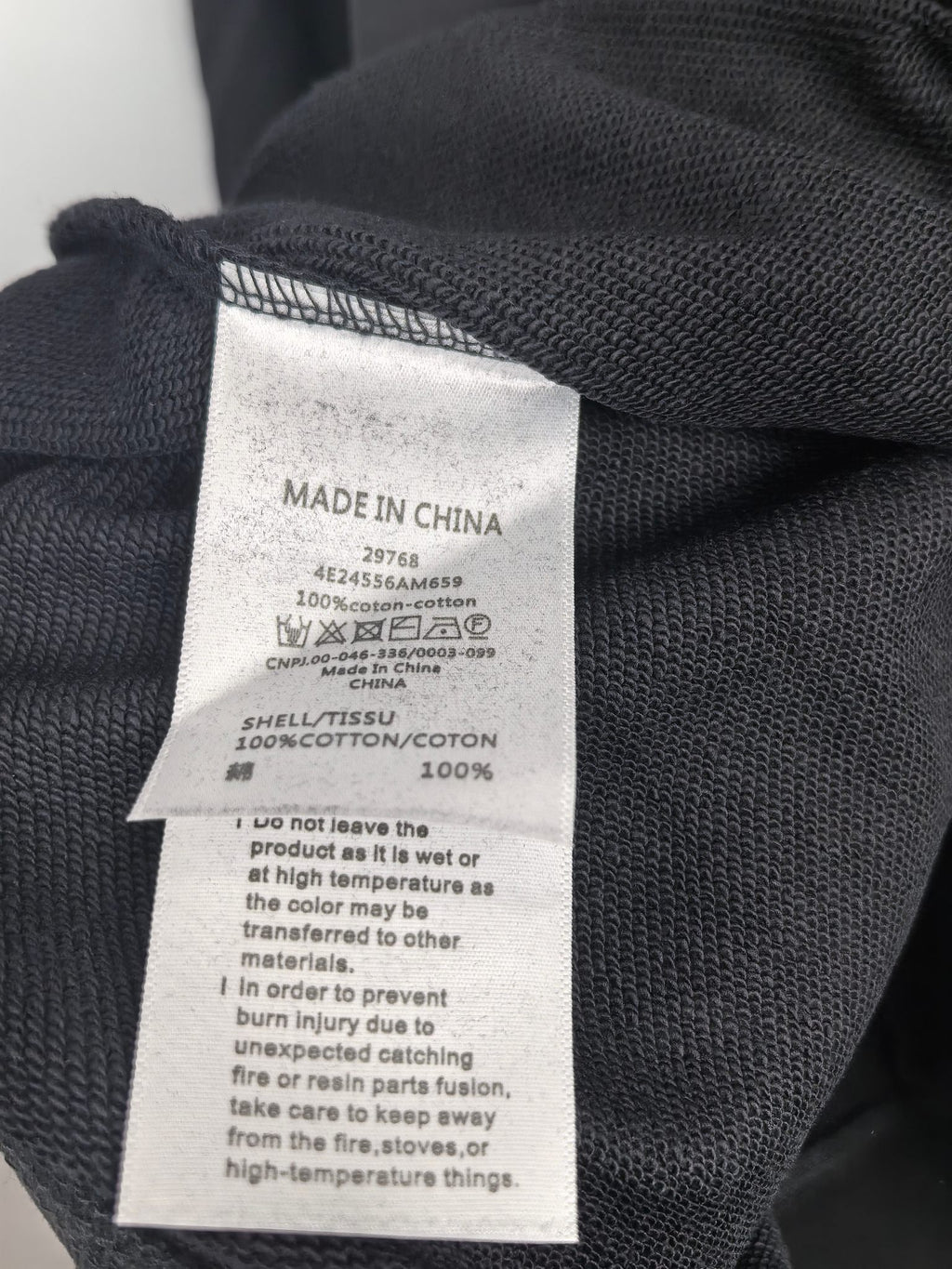 White care label on dark gray sweatshirt: Made in China, 100% cotton