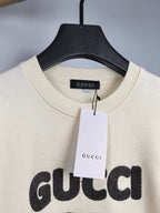 Cream crewneck sweatshirt with Gucci logo tag at neckline