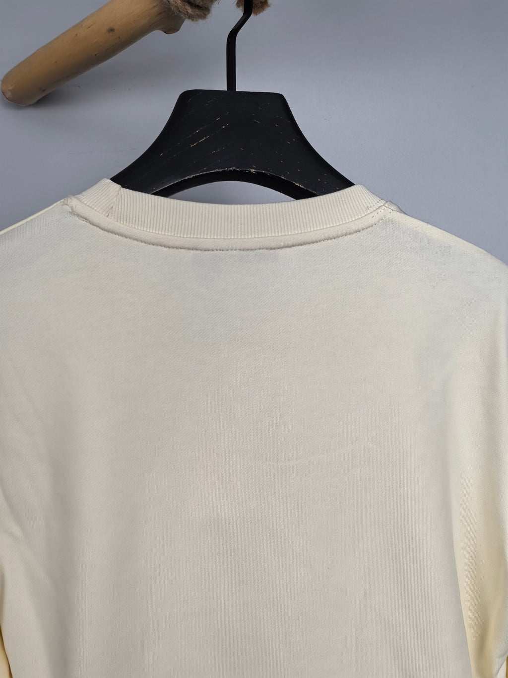 Cream sweatshirt back view, crew neck ribbing on hanger