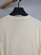 Cream sweatshirt back view, crew neck ribbing on hanger