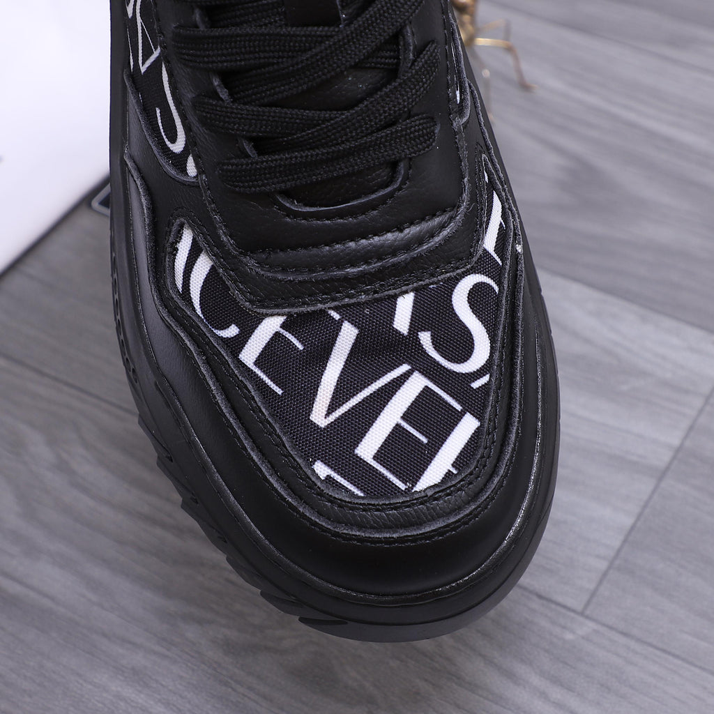 Versace luxury shoes, close-up of black toe with white logo script and lace panel