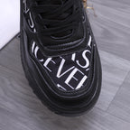 Versace luxury shoes, close-up of black toe with white logo script and lace panel