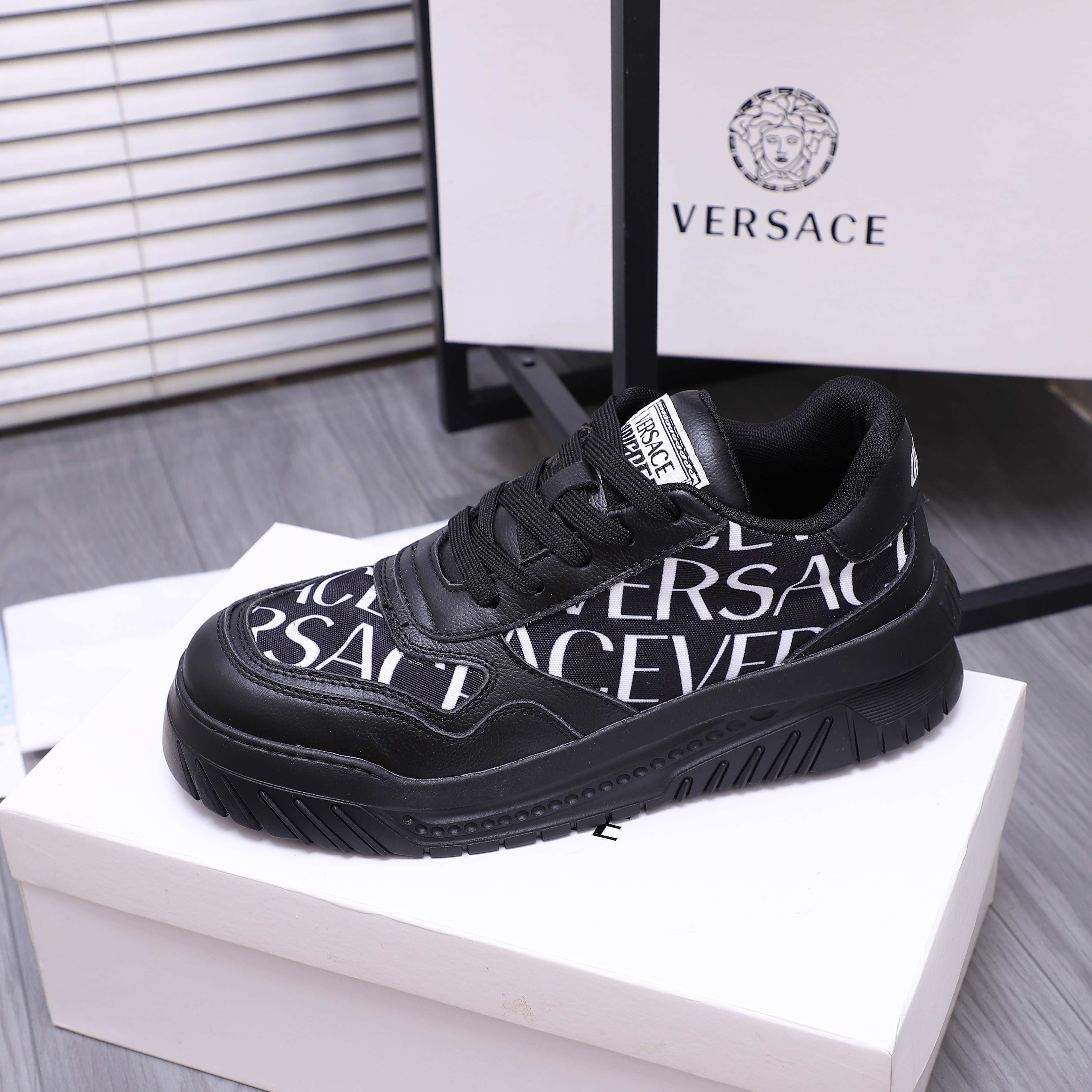 Versace luxury shoes, black logo lace-up sneakers on white shoebox