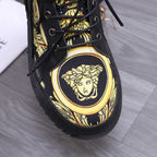 Close-up of black high-top sneaker toe with gold Medusa emblem and lace eyelets