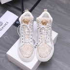 White high-top sneakers with gold-toned medallion, lace-up and patterned panels