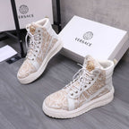 White high-top sneakers with ornate gold pattern, lace-up and gold heel emblem