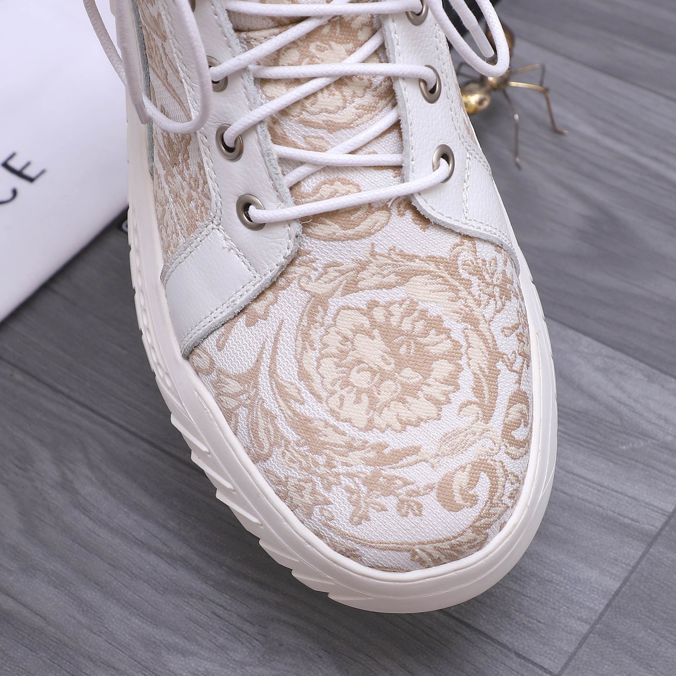 White and gold patterned sneaker upper with lace-up eyelets and textured panel