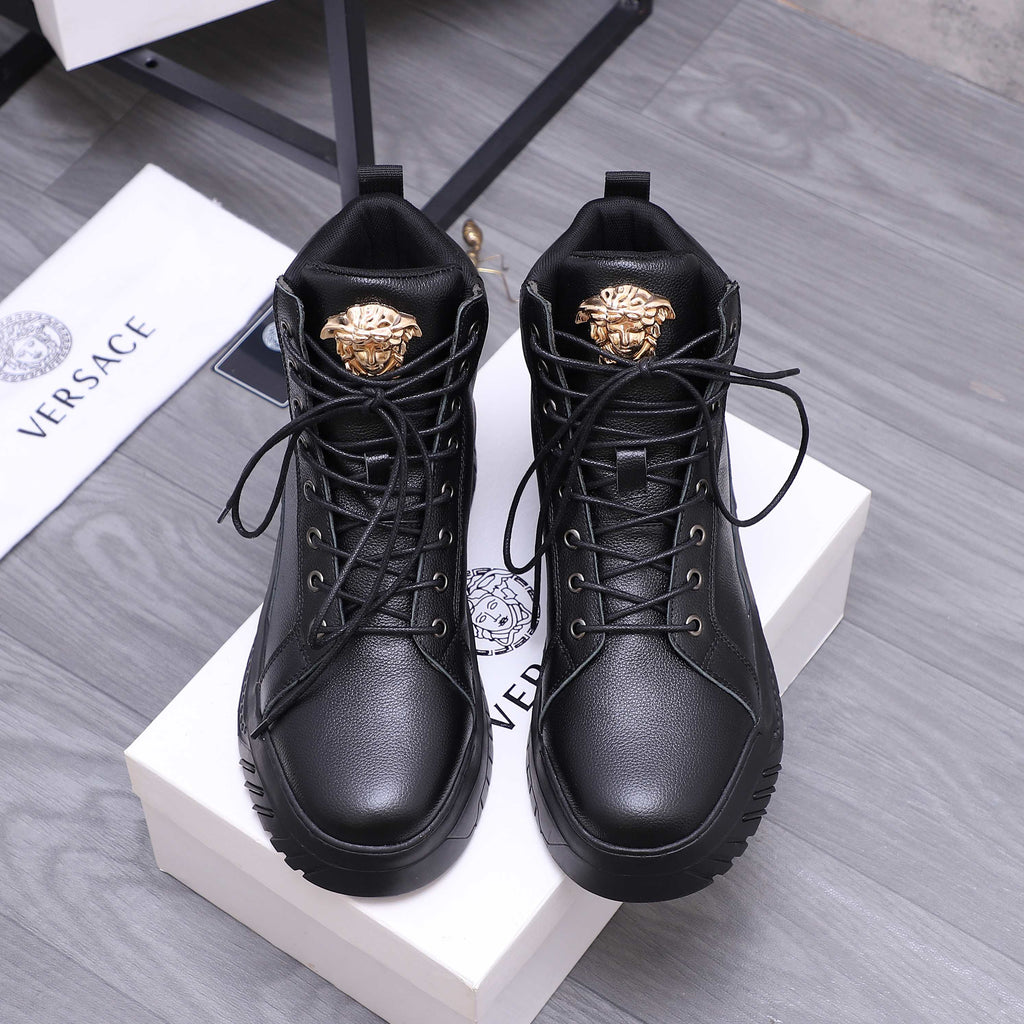 Black lace-up high-top shoes with gold emblem on the tongue and padded collars