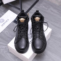 Black lace-up high-top shoes with gold emblem on the tongue and padded collars