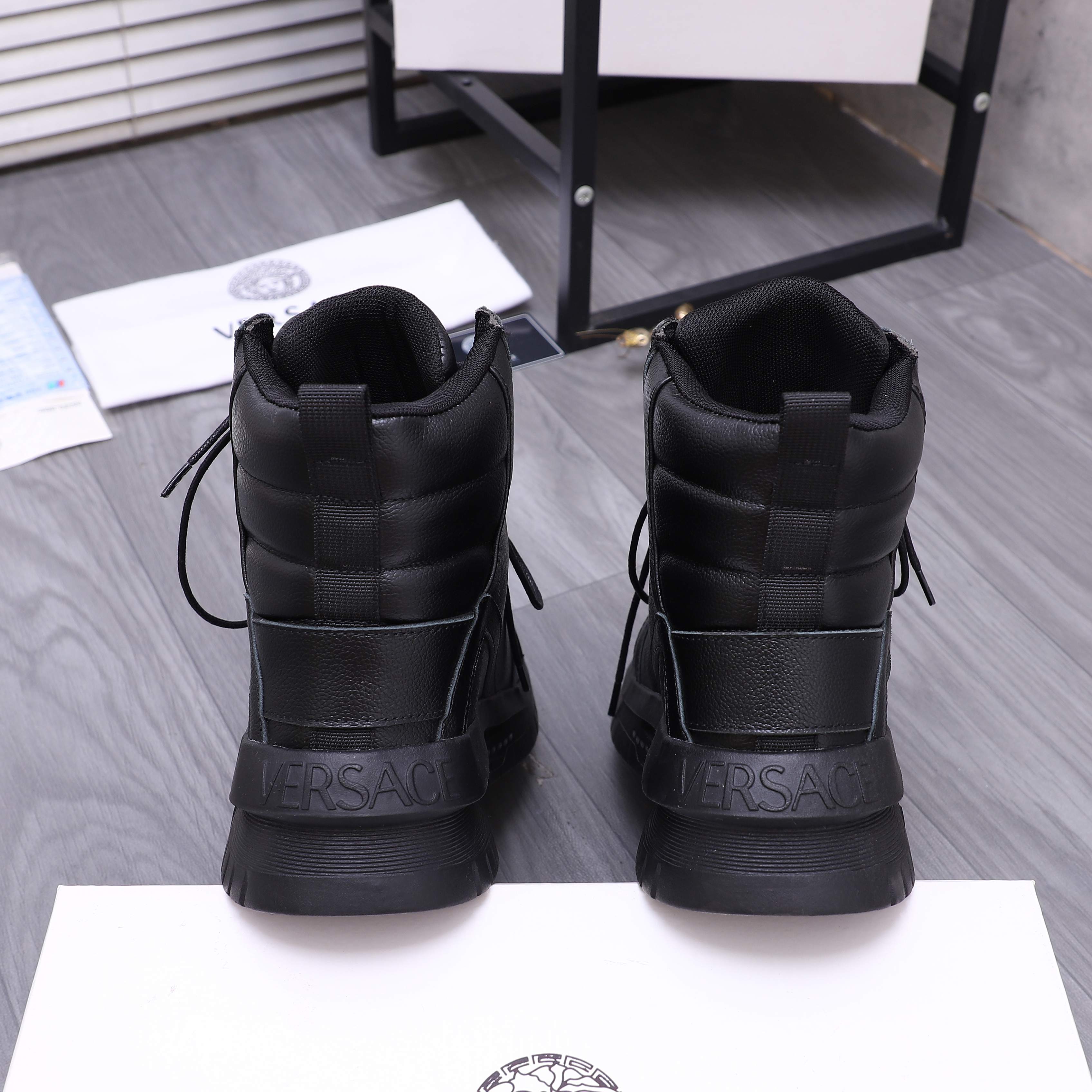 Black lace-up high-top shoes with quilted heel panels and embossed logo on back
