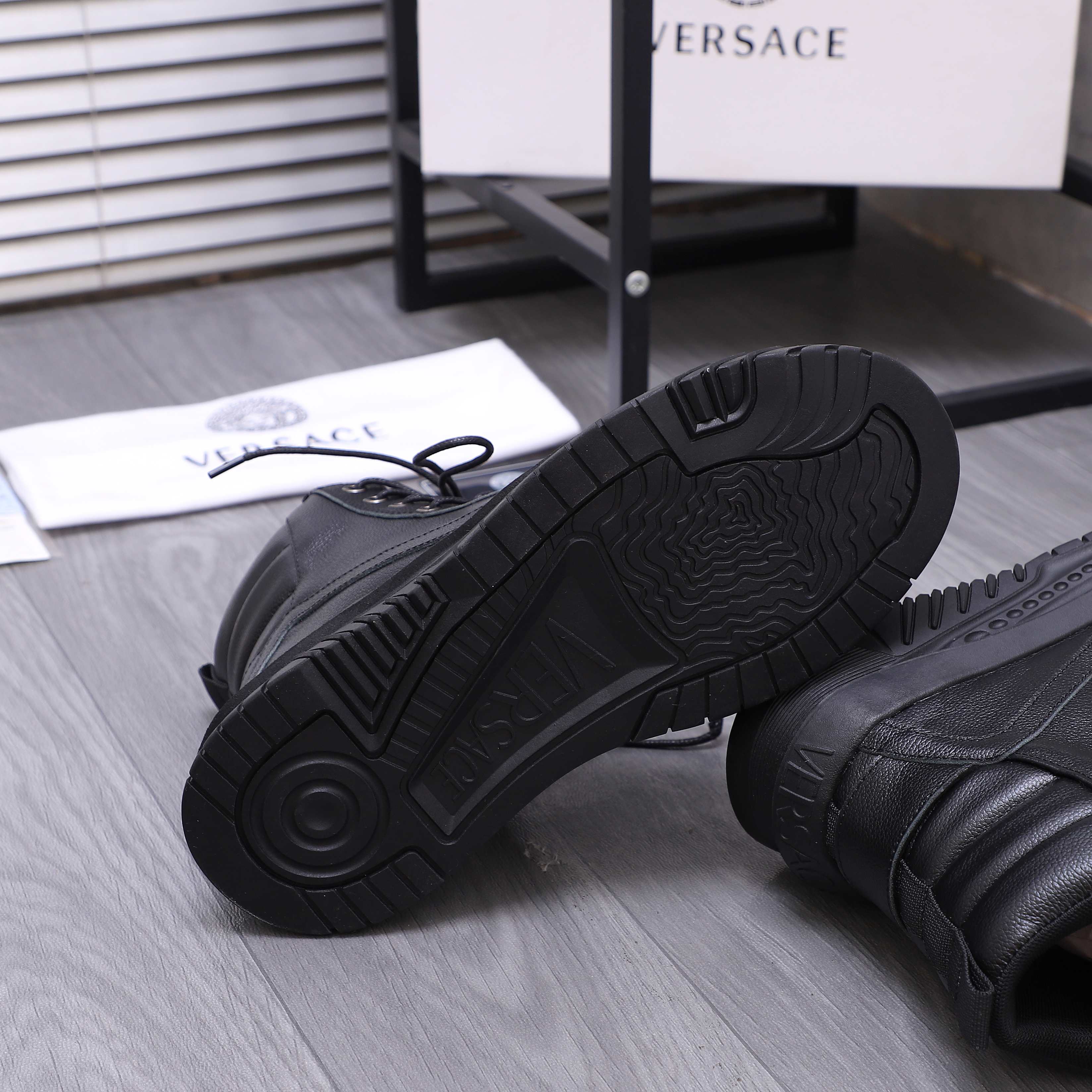 Black shoe outsoles with deep tread pattern on thick rubber soles