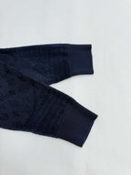 Dark blue ribbed sleeve cuffs and hem with monogram texture, close-up.