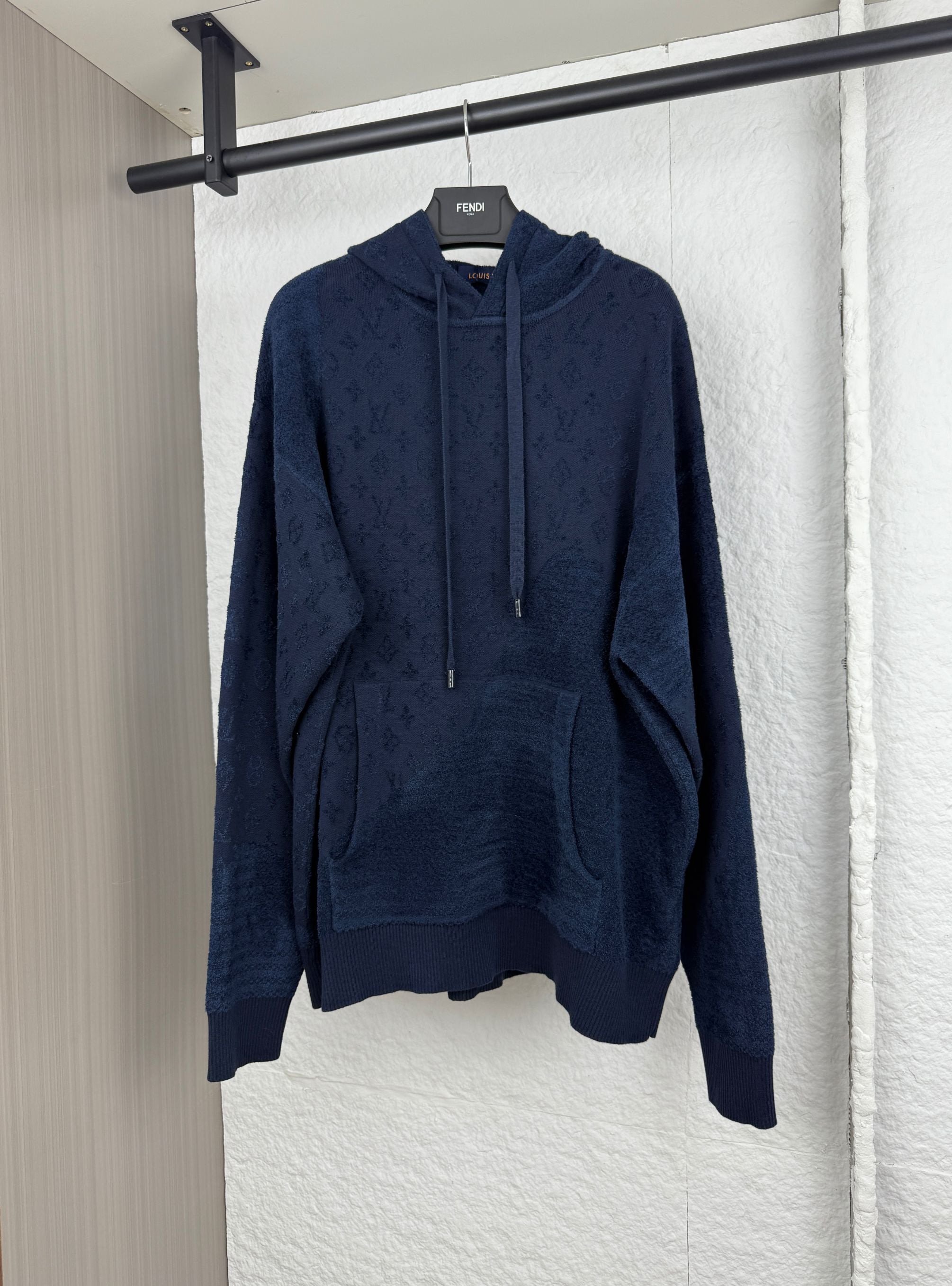 Dark blue long-sleeve hoodie with monogram print, kangaroo pocket, drawstring hood.