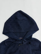 Dark blue monogram hoodie with attached hood and drawstring, close-up.