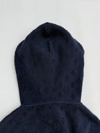 Dark blue monogram hood with front seam, close-up.