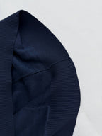 Dark blue hood edge with ribbed trim and monogram texture, close-up.