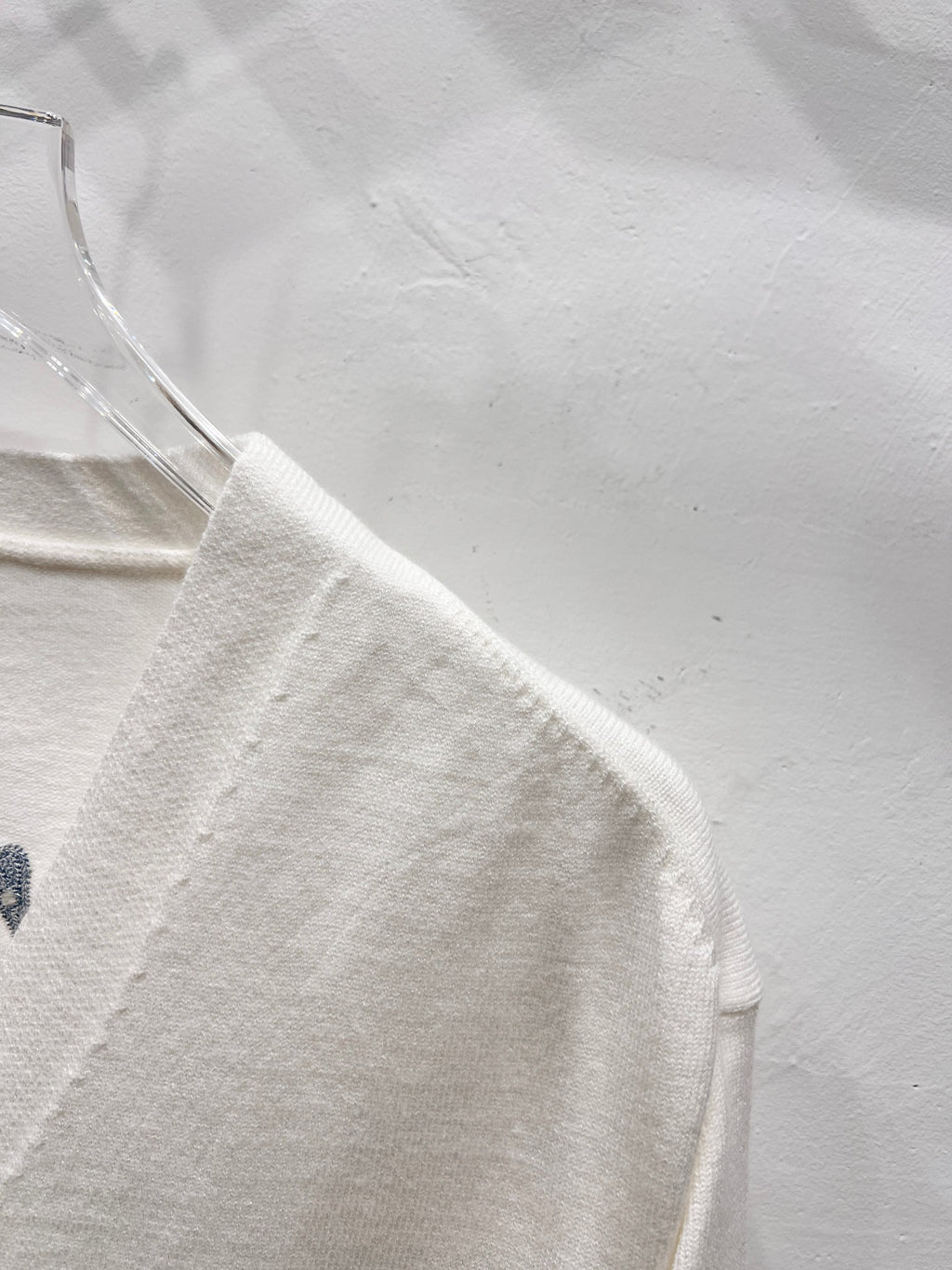 Dior white long-sleeve cardigan side view with smooth fabric and seam detail