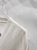 Dior white long-sleeve cardigan side view with smooth fabric and seam detail