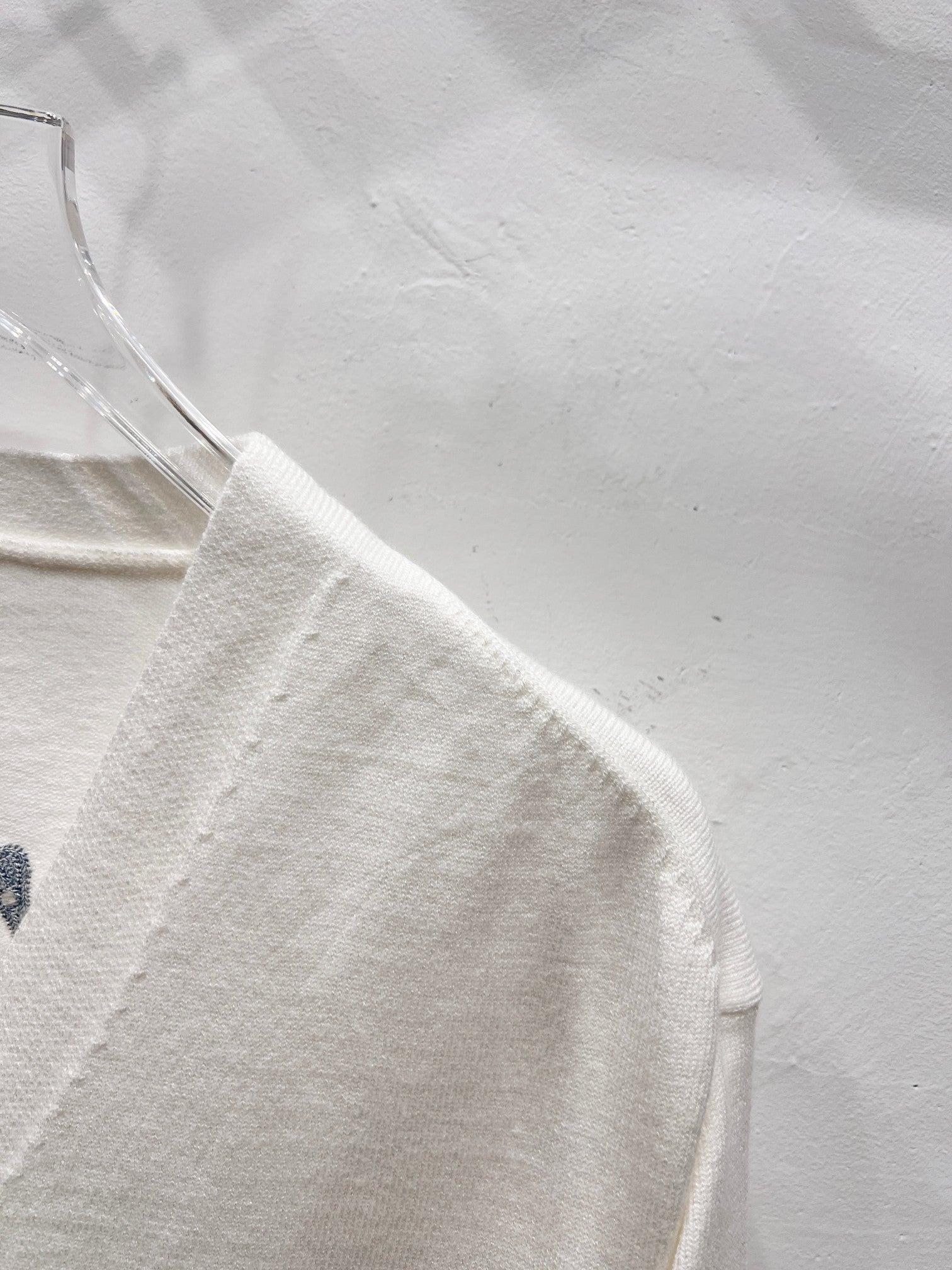 Dior white long-sleeve cardigan side view with smooth fabric and seam detail