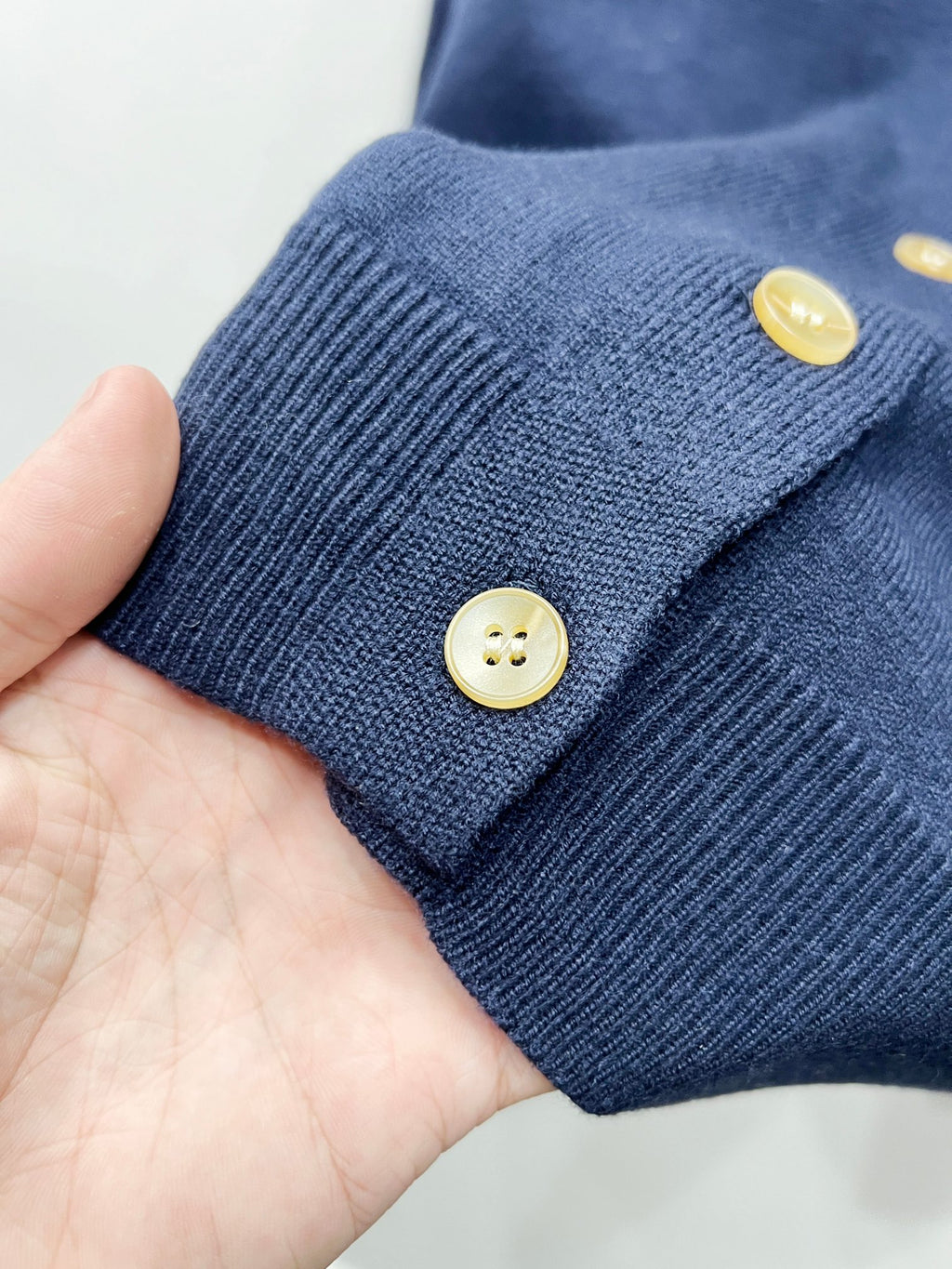 Navy ribbed cuff with two round gold buttons