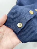 Navy ribbed cuff with two round gold buttons