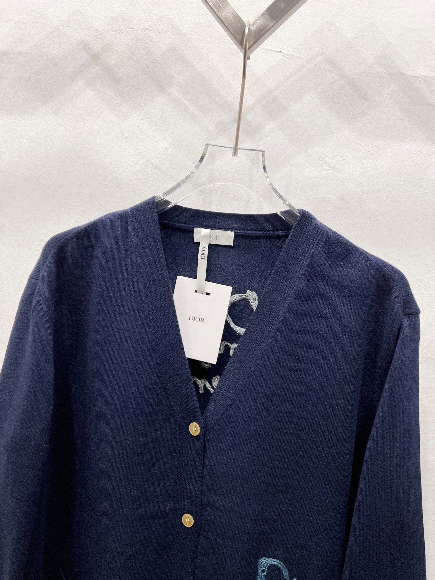 Navy V-neck cardigan with button placket and neckline label