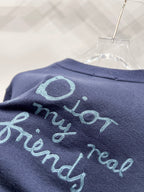 Navy fabric close-up with turquoise embroidered lettering and oval graphic