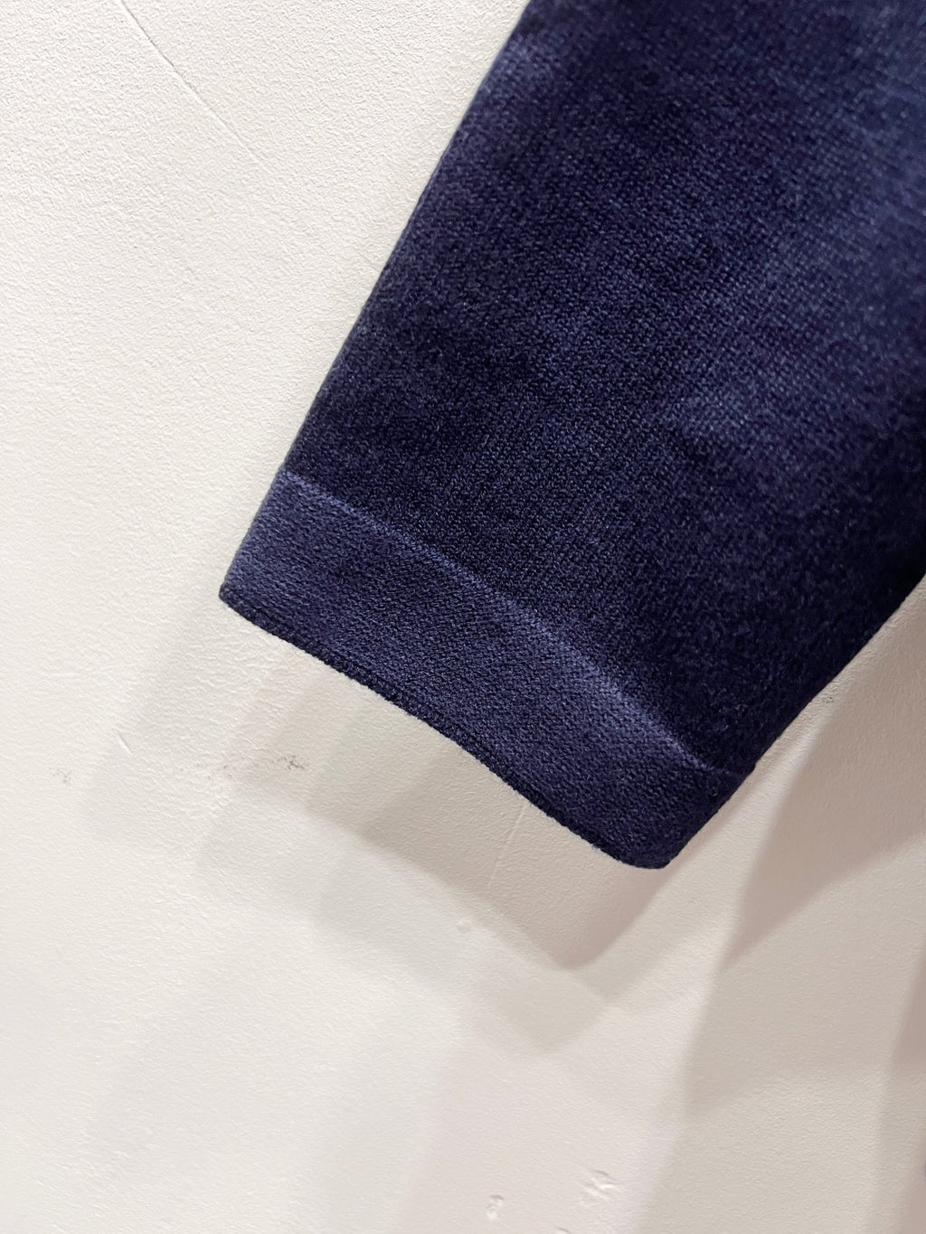 Navy knit sleeve hem with clean stitched edge