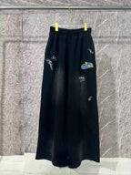 Black wide-leg pants with elastic waist and white embroidered logo on the legs