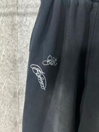 Black pants with white script embroidery on the side