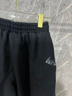 Black pants with elastic waistband and white embroidered logo on the front leg