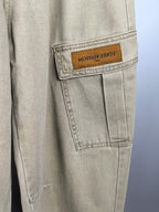 Beige denim pants with stitched pocket seams and tan branded patch