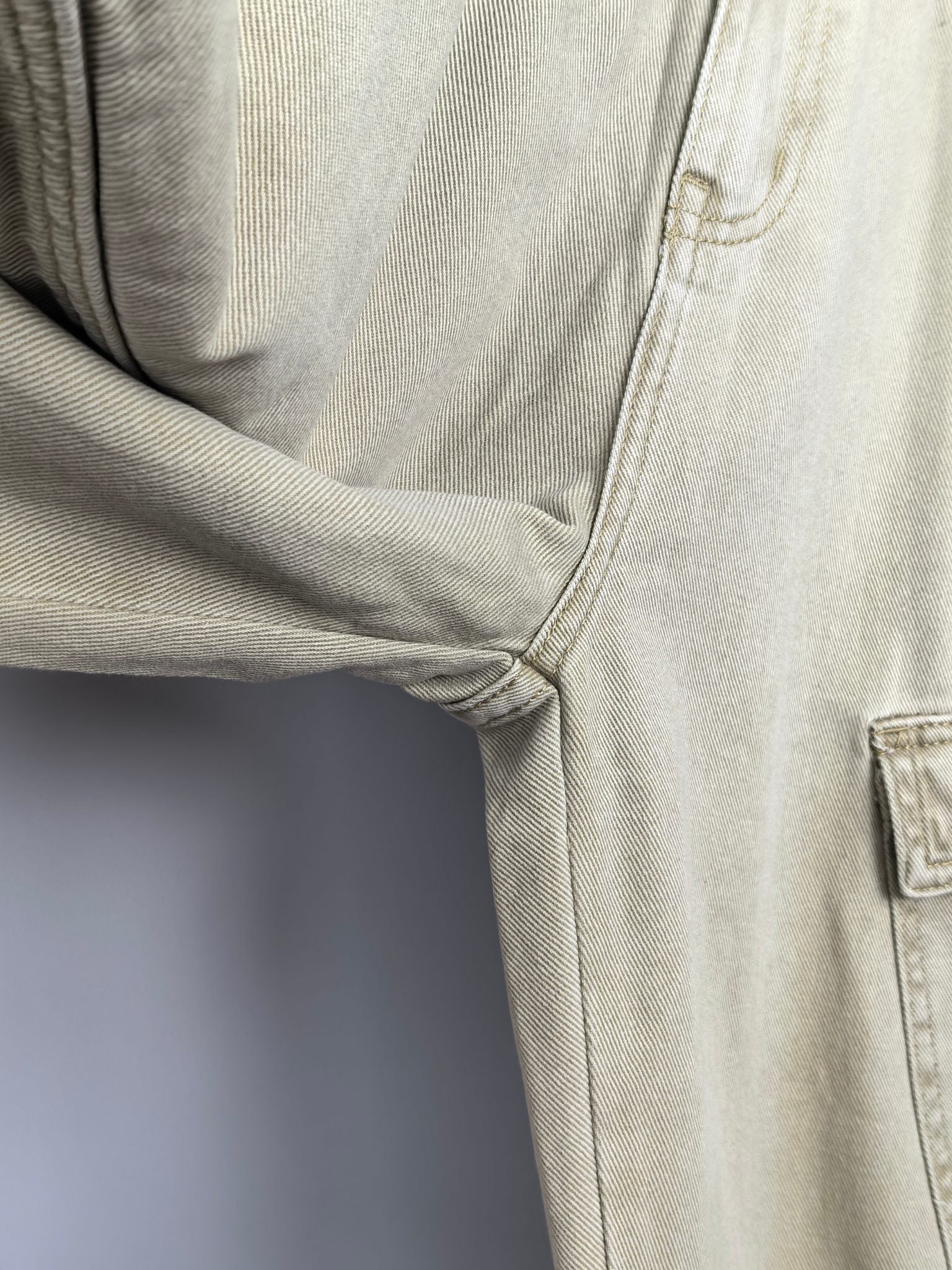Beige denim pants close-up of inner thigh seam and stitched crotch
