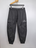 Dark drawstring cargo pants with elastic waist, cuffed legs, side pockets, and GUCCI logo.