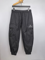 Dark drawstring cargo pants with elastic waist, cuffed legs, side pockets, and GUCCI logo.
