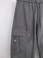Dark cargo pants with elastic waist, drawstring, and front pocket panels.