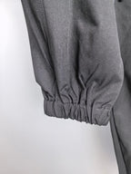 Dark cuffed cargo pants with gathered elastic hem at ankle.